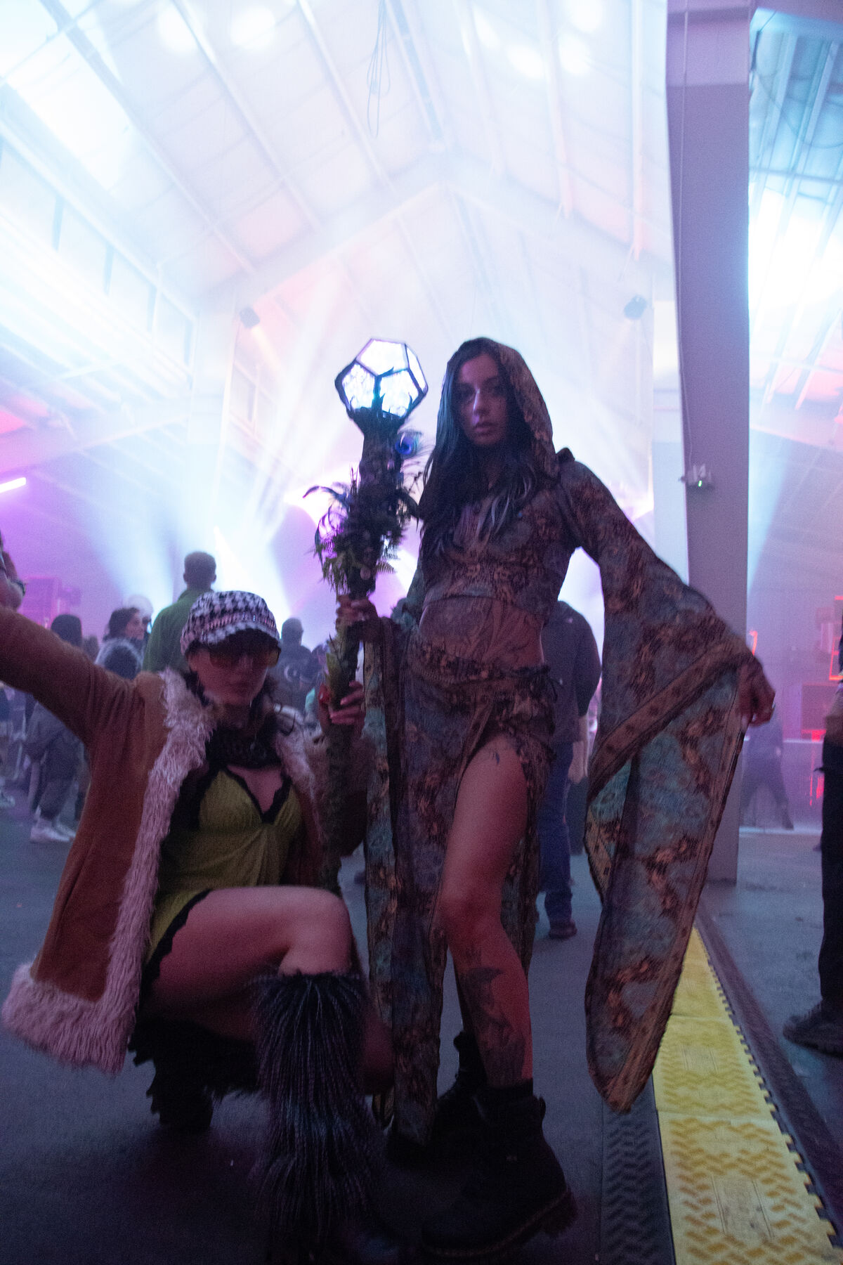 Two people in a hall filled with pink and white stage haze